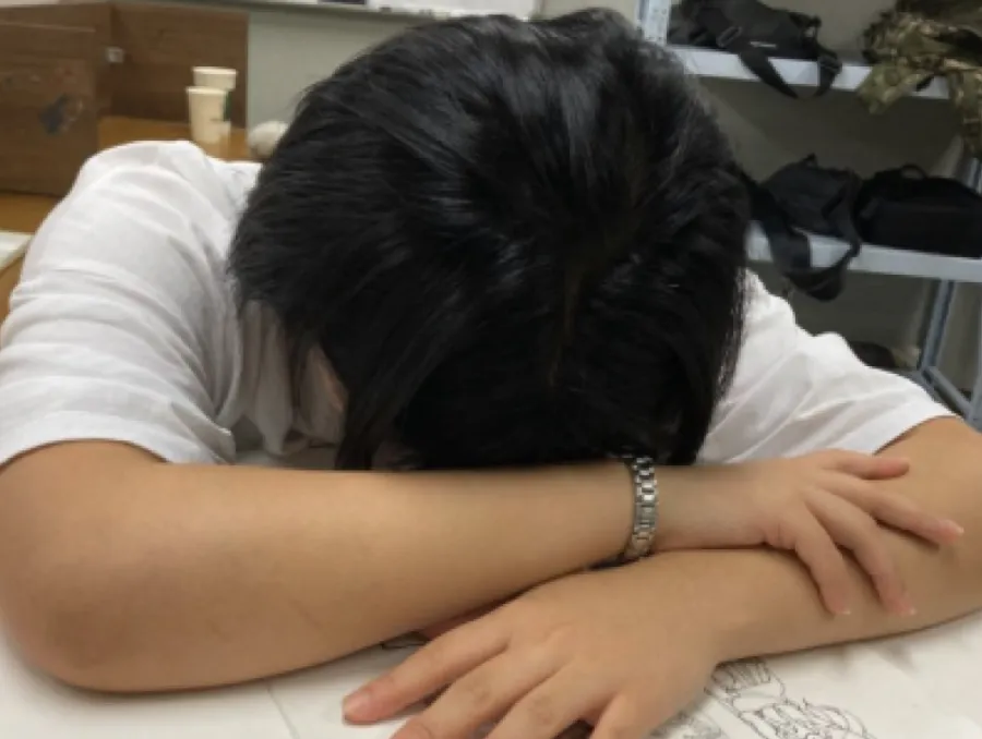 책상에 엎드려 얼굴을 묻은 사람